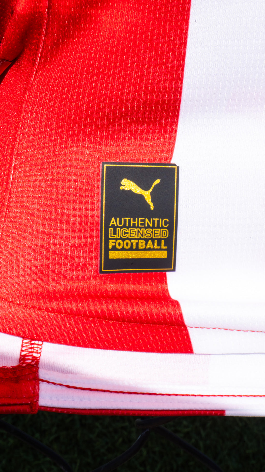 Close-up of a red and white sports jersey with a Puma logo label.