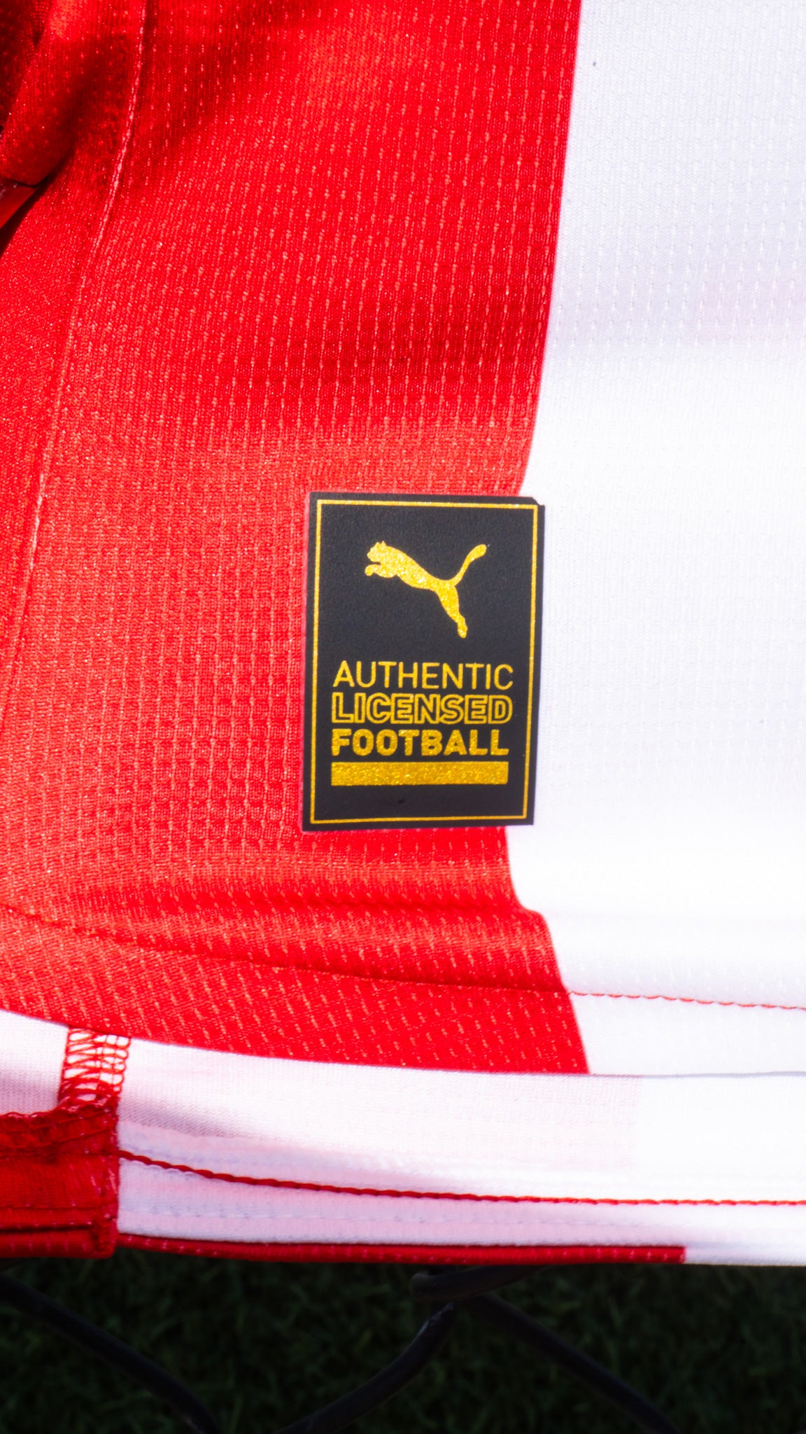 Close-up of a red and white sports jersey with a Puma logo label.
