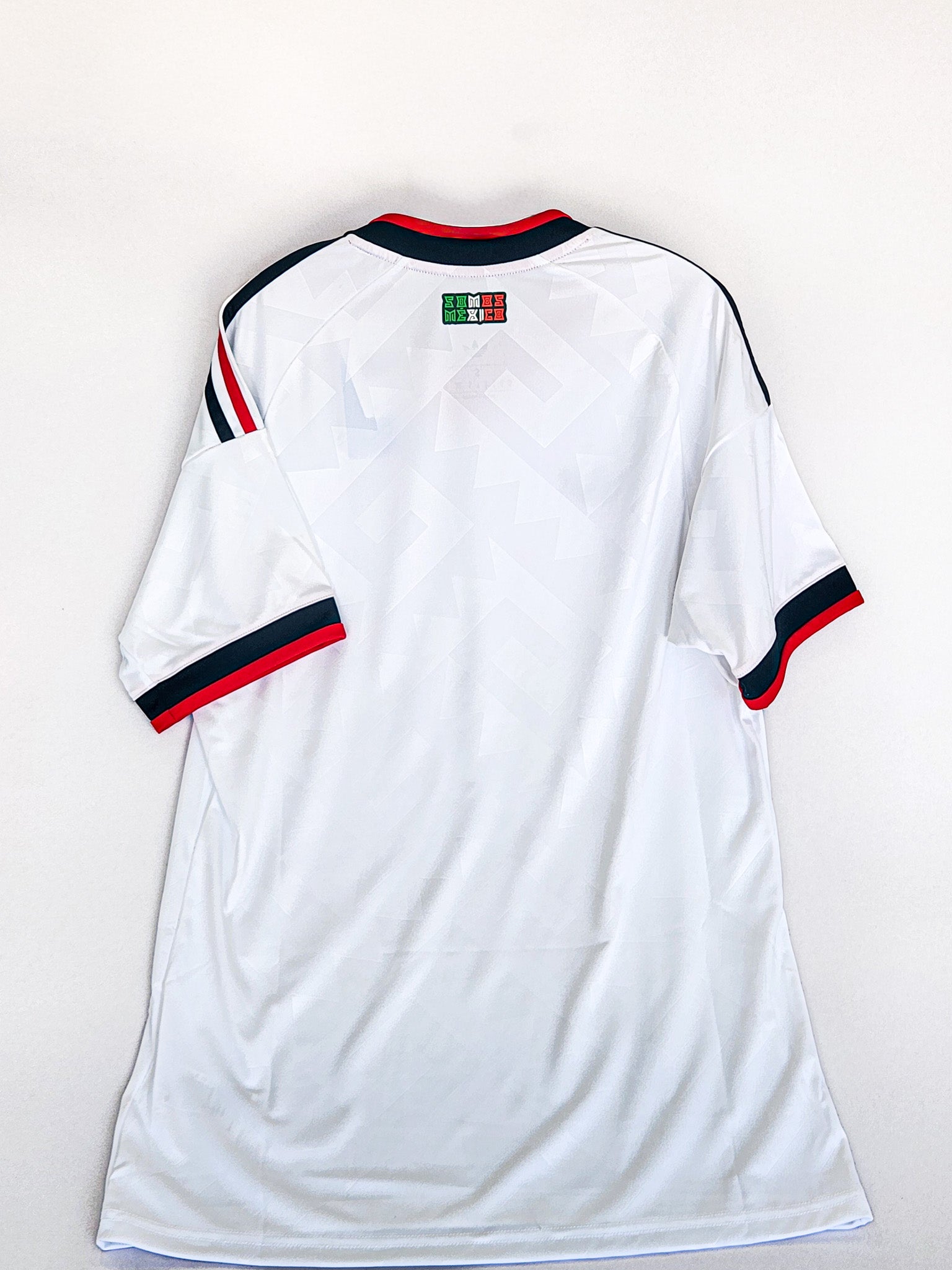 White soccer jersey with red and blue accents on a white background